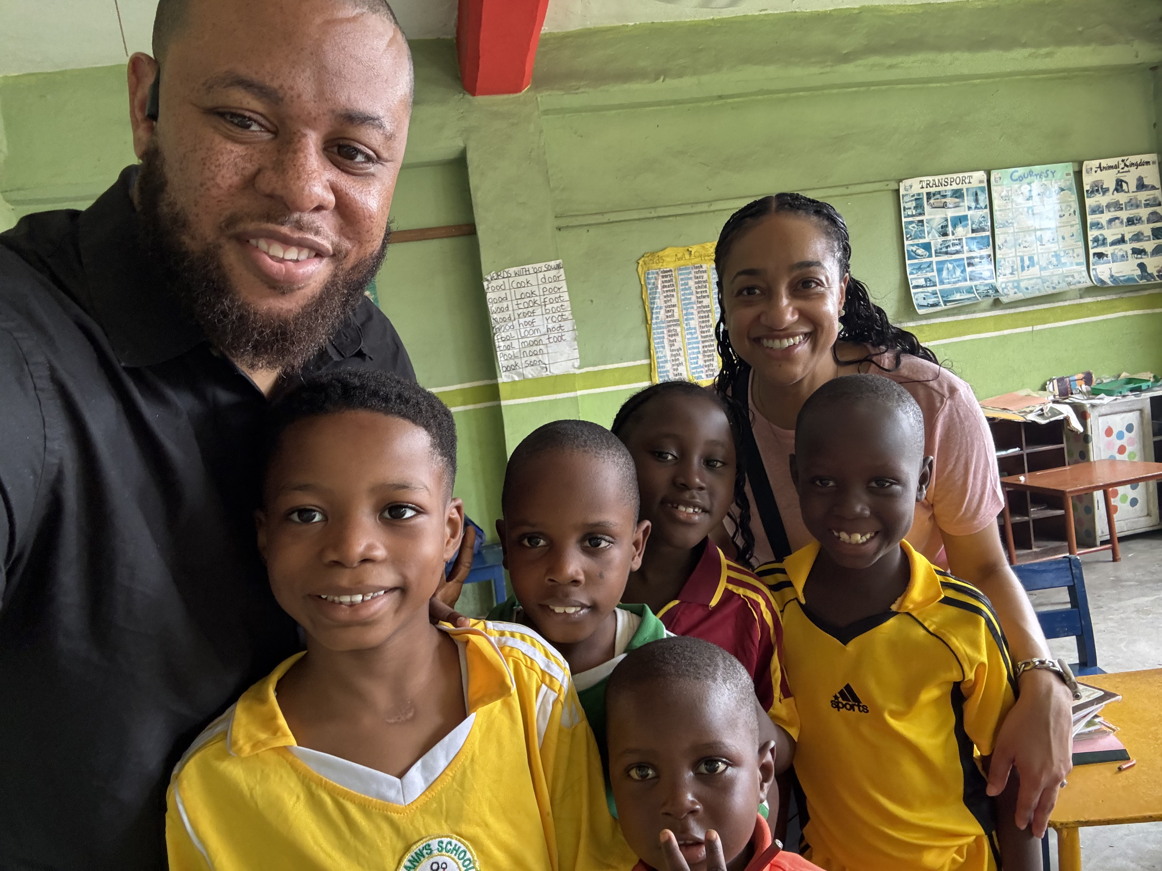 Afara organizers with smiling schoolchildren in a Nigerian classroom